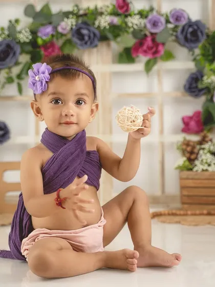 Showing off her little toy, this baby girl is perfectly at ease in front of the camera during her "one" year photoshoot.