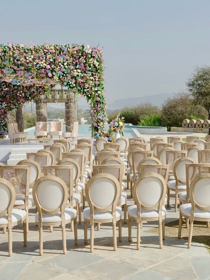 A beautiful shot of the couple sharing a moment during their wedding ceremony. The frame is filled with the vibrant colors of the pastel floral mandap and the joy of their union.
