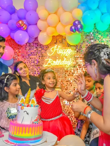 A vibrant unicorn-themed birthday party, complete with a rainbow cake, a sequin backdrop, and a colorful balloon arch.