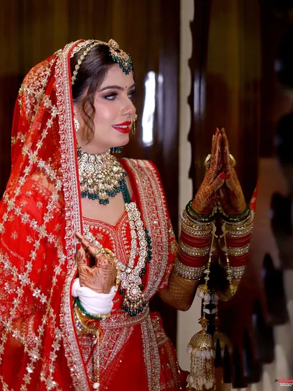 This bride is the picture of happiness and tradition. Her complete look, from the intricate maang tikka to the kalire, is complemented by our classic bridal makeup.