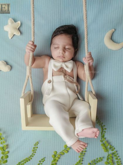 A slightly different angle of the celestial swing setup, incorporating soft green foliage for a touch of nature. We can customize our themes to match your vision.