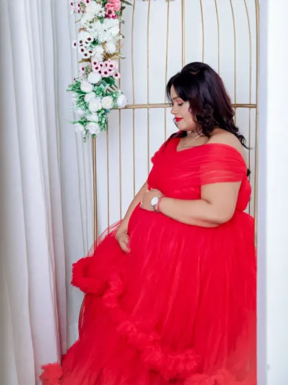 A classic and elegant side profile. The mom-to-be is framed by a window and our birdcage prop, her red gown adding a beautiful pop of color.