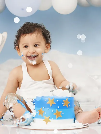 A close-up shot capturing the sheer delight of a baby boy enjoying his star-decorated birthday cake.
