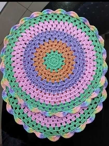 This centerpiece uses a soft pastel palette of green, purple, pink, and orange. The gentle colors and scalloped edge create a dreamy, modern look.