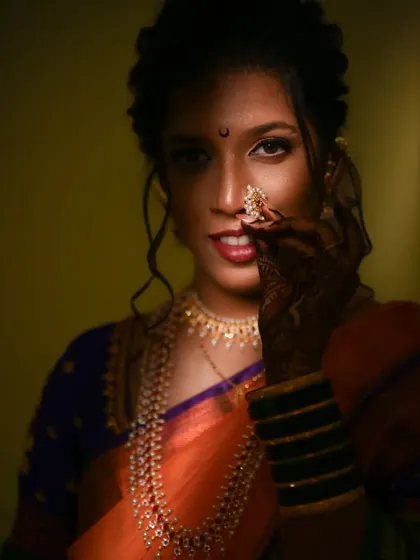 A coy and elegant pose, with the bride partially covering her face with her henna-adorned hand.