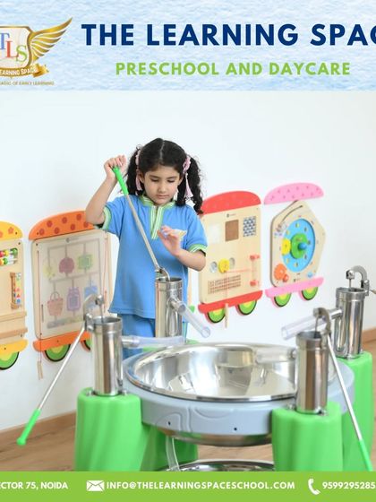A young girl plays a large steel drum instrument. Our music area is designed to be accessible and engaging for children of all ages, encouraging them to make some joyful noise.