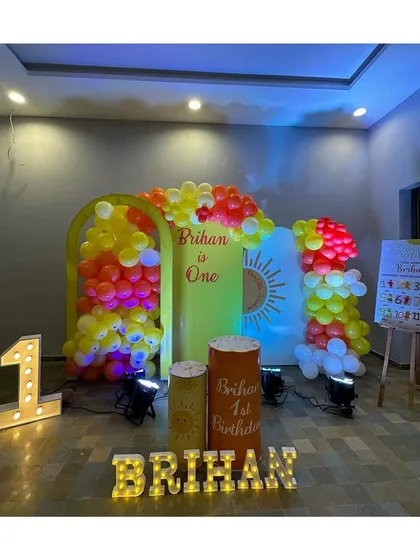 A bright and cheerful "You are my Sunshine" theme for a first birthday, using yellow, orange, and red balloons with sun graphics.