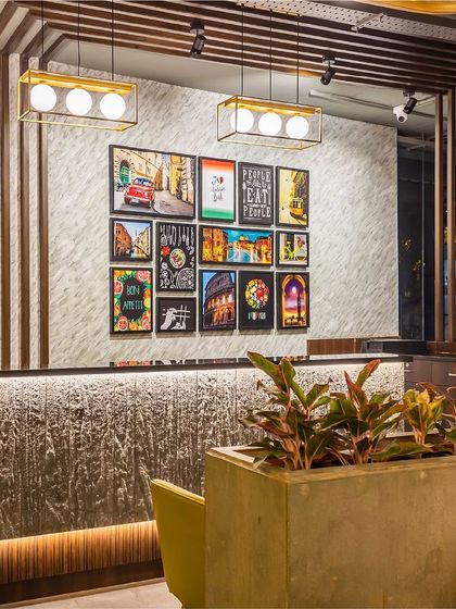 The reception and cash counter area, designed to make a strong first impression. The counter features a raw stone texture with subtle under-lighting, complemented by a wood-fluted panel backdrop and modern geometric pendant lights.