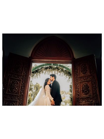 A stunning black and white silhouette of the couple framed by a grand doorway. This artistic shot uses negative space and light to create a powerful image.