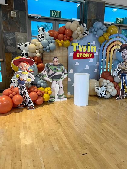 A closer look at the Toy Story backdrop with character cutouts and a custom "Twin Story" sign.