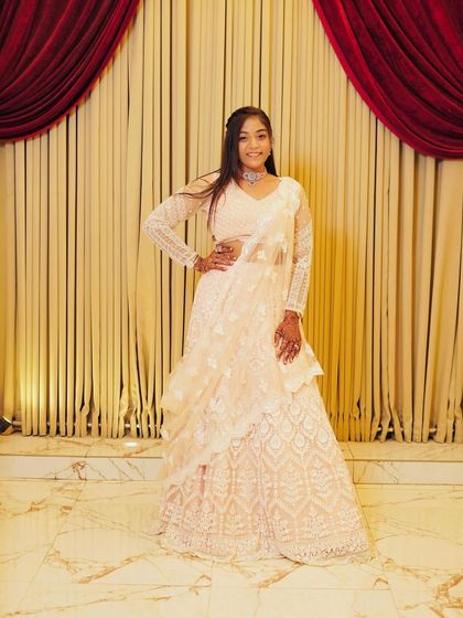 A client posing in the white chikankari lehenga, looking elegant and poised.