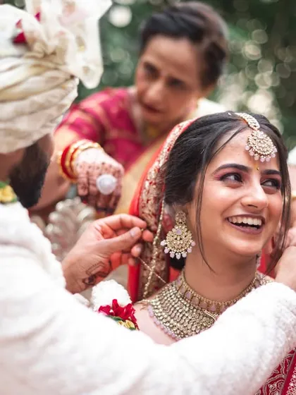 The tying of the sacred thread, a key moment in the wedding ceremony, captured with a focus on the couple's happy expressions.