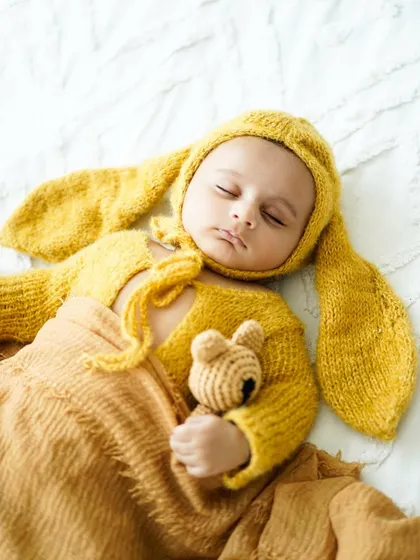 Our little sleepy bunny. Adorable, soft-knit outfits like this yellow bunny costume add a touch of whimsy to newborn photos while keeping your baby comfortable and warm.
