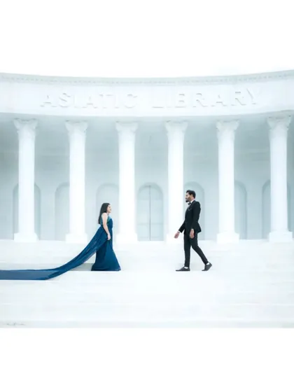 A wide, symmetrical shot of the couple on the steps of the studio set, creating a powerful and cinematic feel.