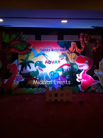 The dinosaur backdrop illuminated with spotlights. The lighting adds drama and highlights the vibrant colors of the theme, making it look great in photos and videos.