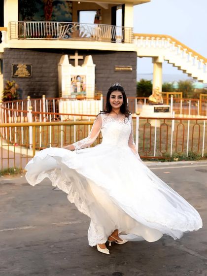 A joyful shot of a woman twirling in the white gown, showing off its flowing skirt.