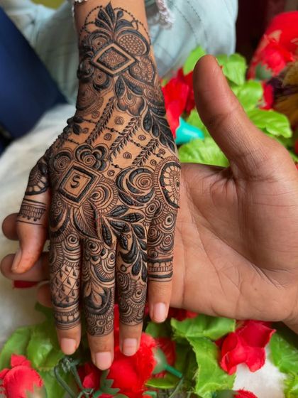 A sweet photo showing the henna design with the initial 'S' held in a partner's hand.
