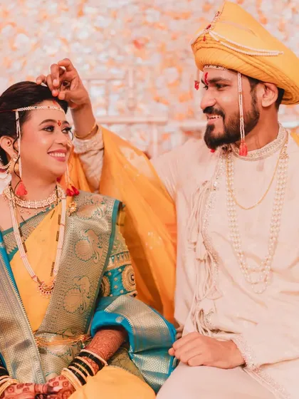 A sweet moment between the bride and groom. Her traditional Maharashtrian look, complete with the mundavalya, is a beautiful tribute to her culture.