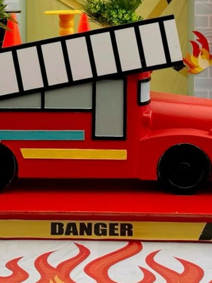 A close-up of the bright red firetruck prop, complete with a ladder and 'DANGER' sign.