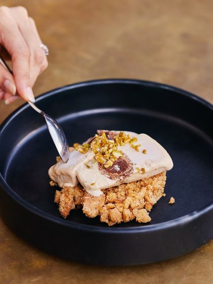 A close-up of the Salted Chikki Kulfi, showing the moment of indulgence. This dessert is a testament to our philosophy of reinterpreting familiar Indian sweets in a modern way.