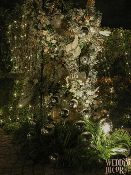 An ethereal floral installation for an outdoor evening party. I combined clouds of baby's breath, dried palms, and silver disco balls with fairy lights to create this magical, glowing structure.