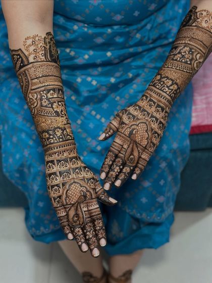 The full view of this bride's arms, adorned with traditional motifs and patterns.