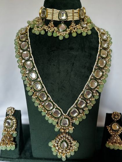 This pastel green bridal set includes a choker, a long Kundan necklace, and matching jhumka earrings. It's a beautiful rental option for a daytime wedding.