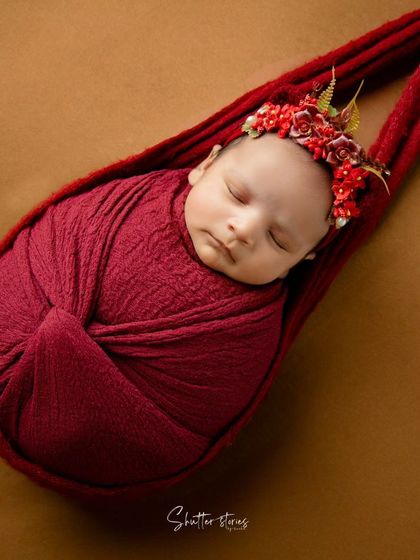 A slightly different angle of the red sling shot, focusing on the baby's peaceful expression.