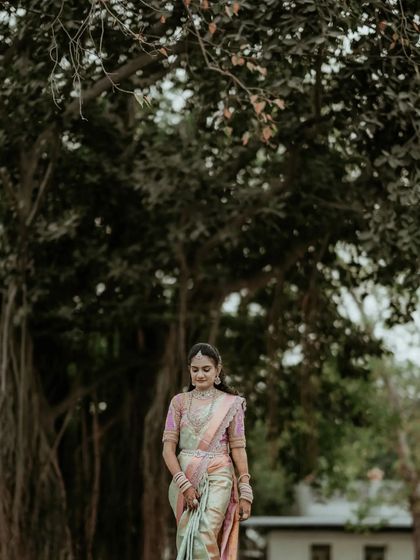 A portrait of the bride walking in a park, her beautiful pastel saree flowing gracefully.