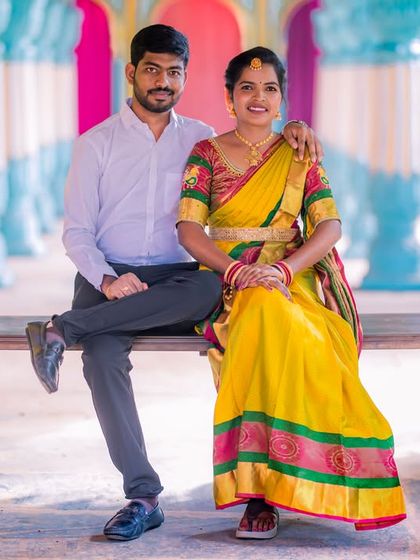 A happy couple on a swing set against the colorful backdrop of our Jaipuri palace set, perfect for a fun and vibrant traditional shoot.