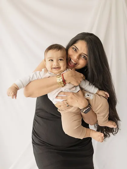 A playful, energetic shot of a mother and her happy baby.