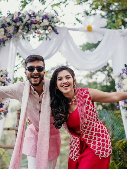 A fun and energetic pose from the couple at their outdoor Haldi celebration.