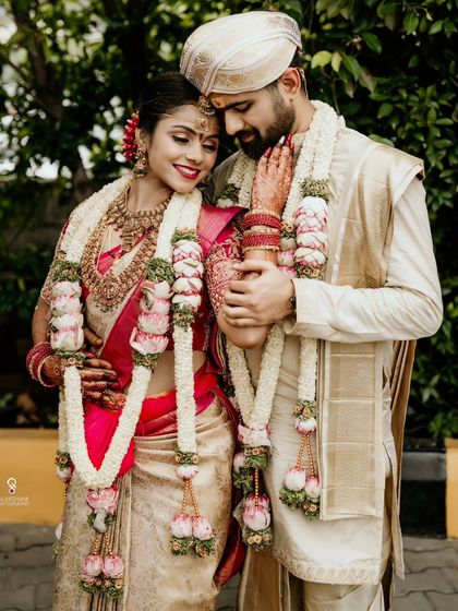 A classic portrait of the couple in their traditional wedding attire, embracing tenderly.