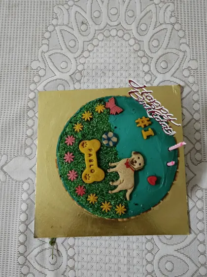 A close-up of the custom birthday cake I made for Pablo. I design every cake to be completely dog-safe and decorate it with fun themes, like this garden design with a little bone that has his name on it. It’s the centerpiece of the celebration.