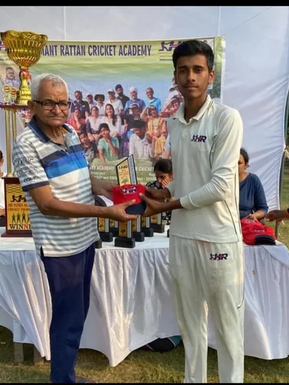 Rishi Sharma receiving an award for his outstanding bowling performance.