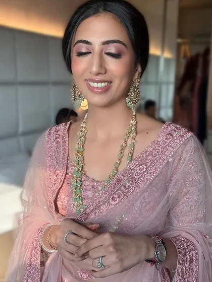 A glowing wedding guest ready for the celebration. We created this soft glam look featuring shimmering pink eyeshadow and a radiant complexion, ensuring she looked and felt her best while complementing the bride's party.