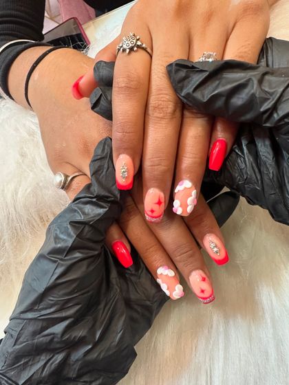 A playful and cute design featuring bright red nails with 3D fluffy clouds, stars, and rhinestone accents.