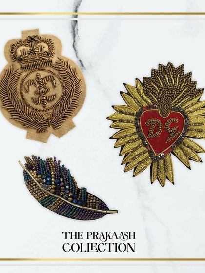 A collection of three distinct hand-embroidered patches: a naval-style crest, a sacred heart motif, and a colorful beaded feather. This shows the diverse range of styles we offer for customization.