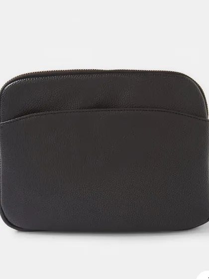 A front view of the Australia Crossbody bag in black. It features a simple, clean design with a front slip pocket and a secure zip top.