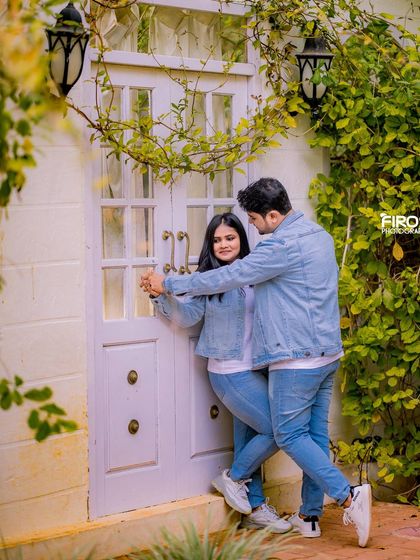 A playful and fun dance in front of a rustic white door with climbing vines.