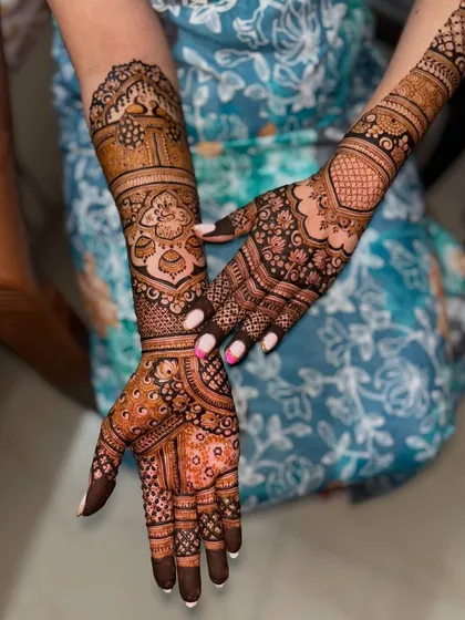 A stunning full-arm bridal design with intricate details. The patterns include traditional motifs like paisleys and florals, creating a classic and timeless look for the bride.