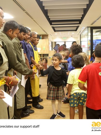 A line of kindergarteners eagerly waits to give their handmade cards to our custodial staff. This activity was part of a week-long celebration of our school community helpers.