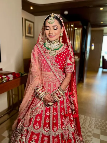A full-length shot of the bride, ready for her ceremony. The entire look, from the makeup to the double dupatta draping, is meticulously styled.