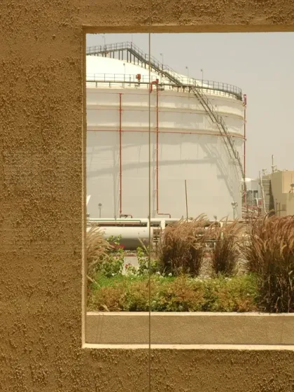 A carefully composed window at the Sohar office frames a view of the industrial landscape. This act of framing creates a deliberate connection to the building's context and purpose.