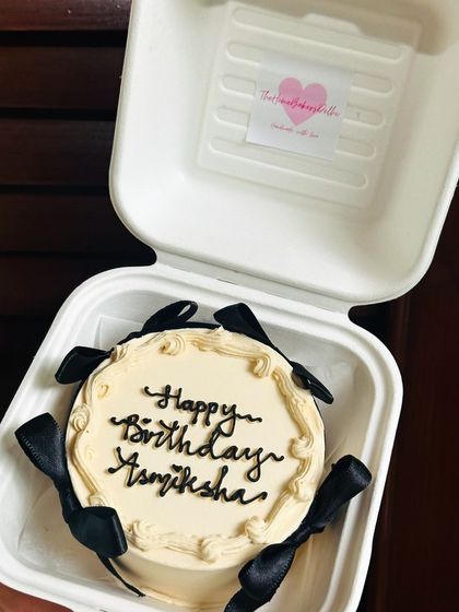 A chic and elegant bento cake with black ribbons and beautiful calligraphy. This design is perfect for a sophisticated birthday celebration.