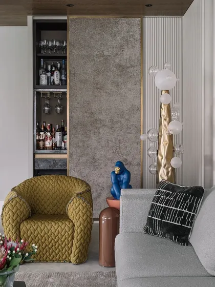 Interior designer Ajay Arya's own Kolkata home features a stylish living area with a hidden bar, a quirky blue gorilla sculpture, and a mix of textures.