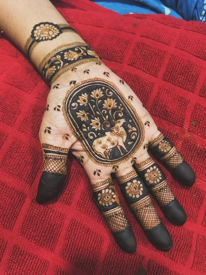 I love creating unique motifs, like this Pichwai-inspired art featuring a cow and calf. The central portrait is framed by lotus flowers and delicate dot work, with fully shaded fingertips to complete this elegant design.