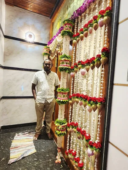 A full view of an intricately decorated doorway for a housewarming. I used multiple layers of flower garlands, including ones with hanging coconuts and parrots.