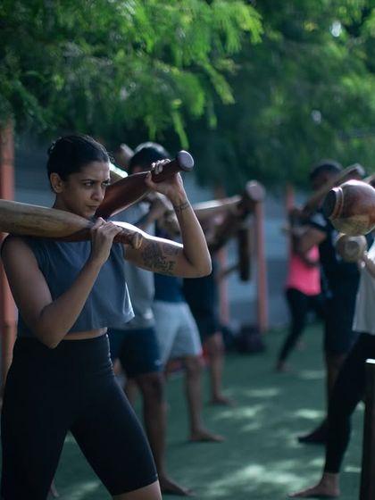 Women training together, barefoot on the turf, using traditional Mudgars. This image captures the essence of our community: authentic, grounded, and strong.