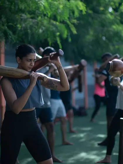 Women training together, barefoot on the turf, using traditional Mudgars. This image captures the essence of our community: authentic, grounded, and strong.